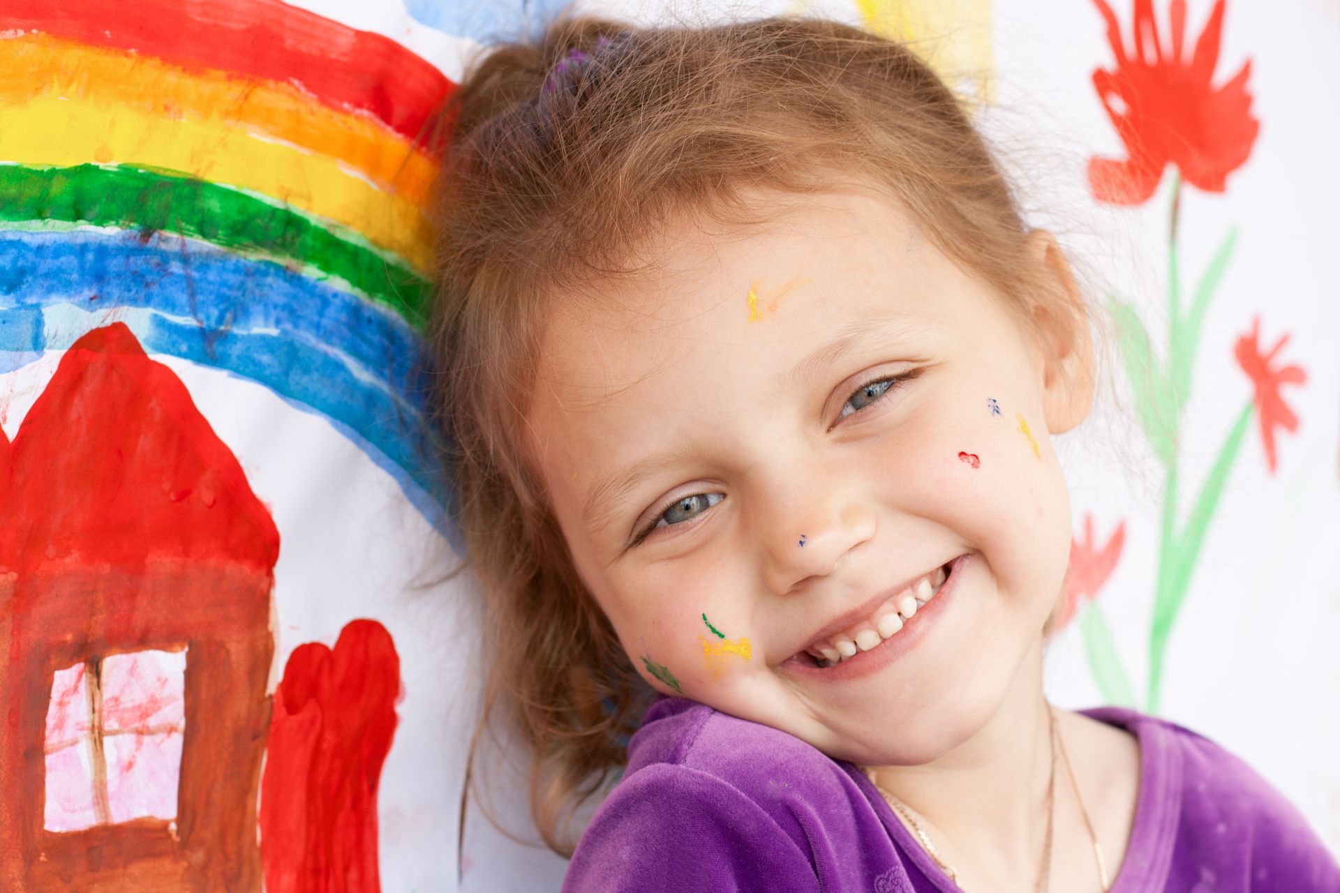 Dziecko bawiące się drewnianymi klockami na dywanie